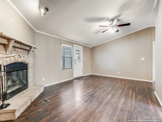 a view of empty room with wooden floor and fireplace