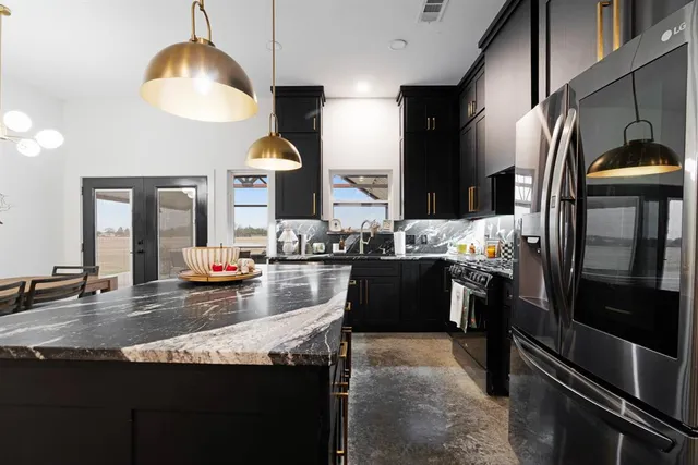 a kitchen with stainless steel appliances granite countertop a sink counter space and refrigerator