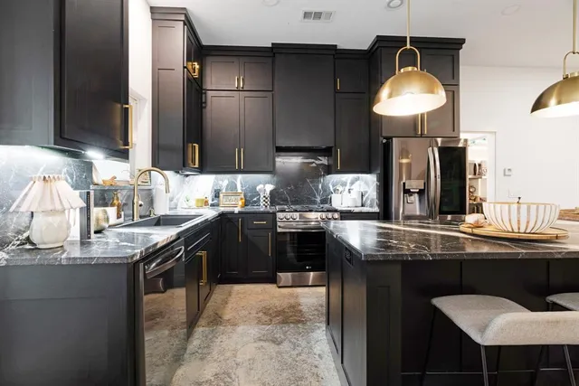 a kitchen with granite countertop a sink and a stove