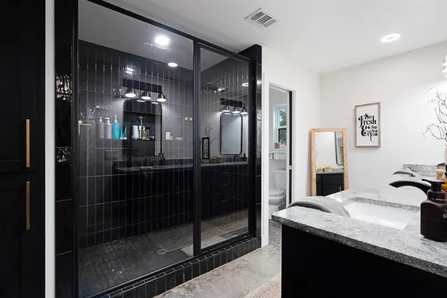 a bathroom with double vanity and a shower