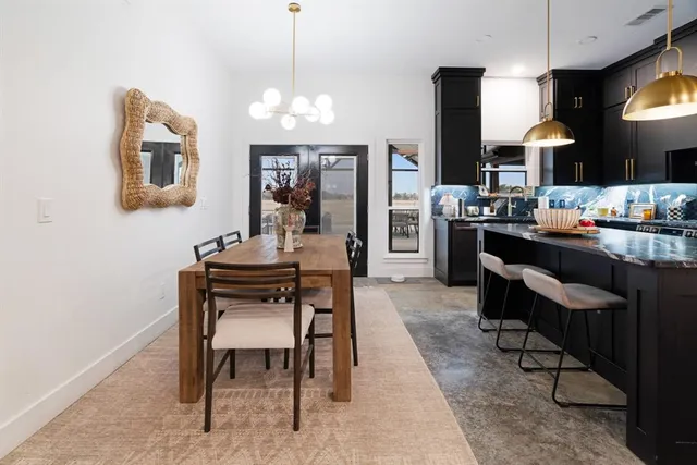 a dining room with wooden floor a chandelier a wooden table and chairs