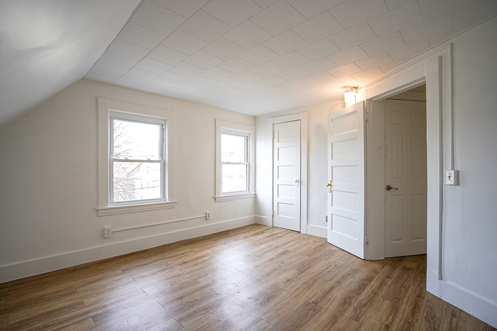 83-85 Wilmont Street, Unit 3 Springfield, MA 01108 - Photo 7 of 12 an empty room with wooden floor and windows