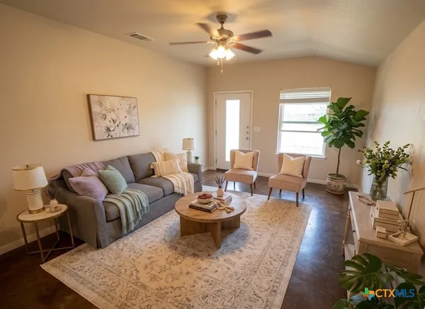 a living room with furniture a window and a potted plant