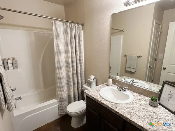 a bathroom with a granite countertop sink toilet and shower