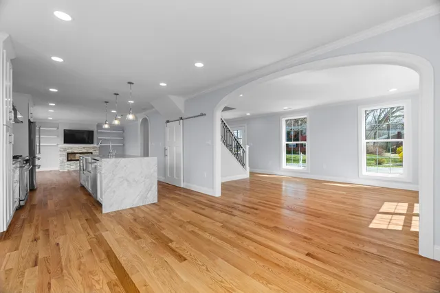 a view of a kitchen with kitchen island a sink wooden floor and a large window
