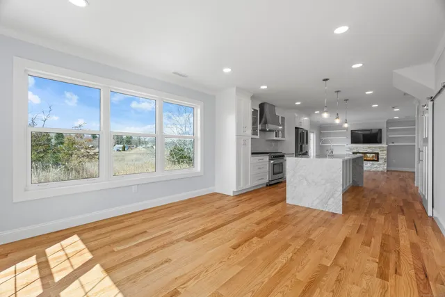a view of kitchen with kitchen island a window a counter top and stainless steel appliances