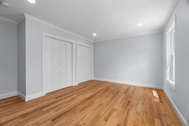 a view of empty room with wooden floor