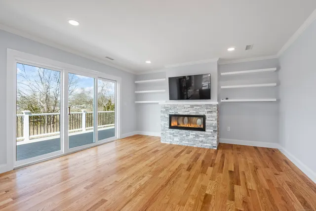 a view of a livingroom with a fireplace wooden floor and window
