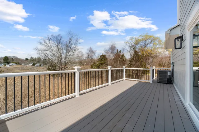 a view of a balcony with wooden floor and fence