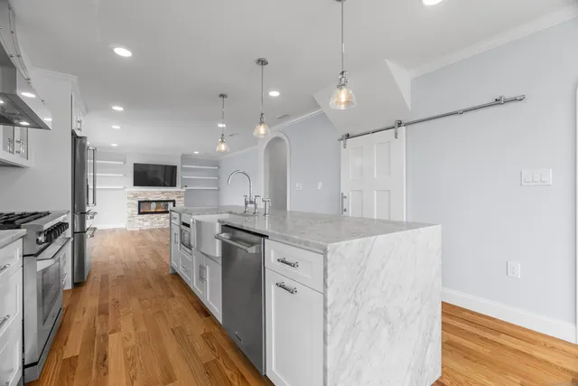 a large kitchen with stainless steel appliances kitchen island a large counter top and a sink