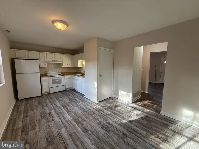 a kitchen with granite countertop a refrigerator and a stove top oven