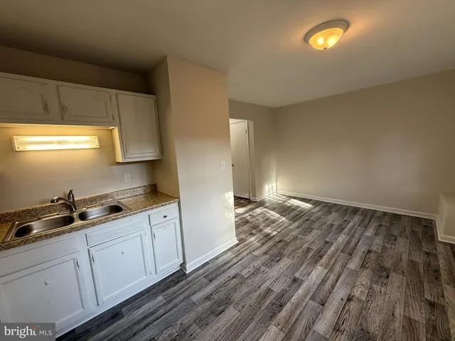 a kitchen with cabinets and wooden floor