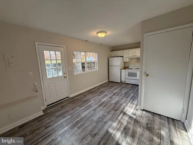 a view of empty room with kitchen and window