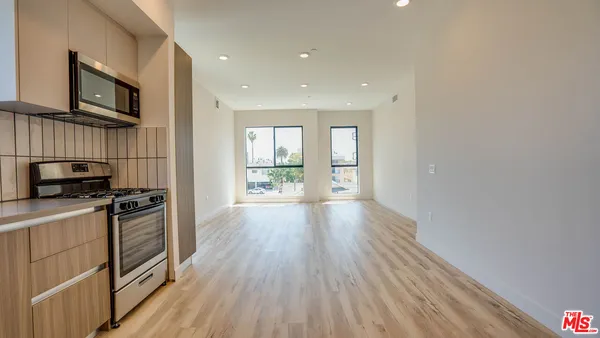 a kitchen with wooden floors and stainless steel appliances