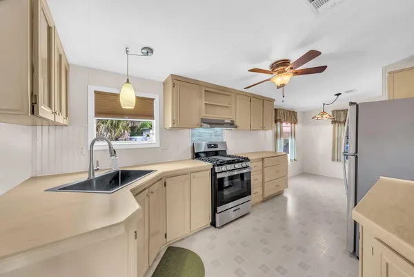 a kitchen with stainless steel appliances granite countertop a sink a stove and a refrigerator