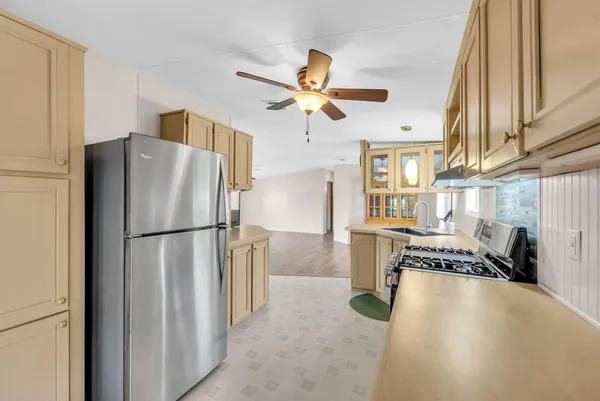 a kitchen with stainless steel appliances granite countertop a refrigerator a stove and a sink