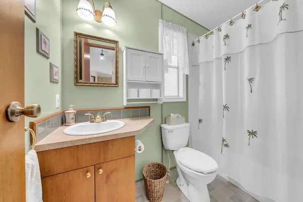 a bathroom with a granite countertop sink toilet a mirror and shower
