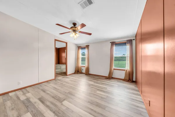 a view of an empty room with closet and a window