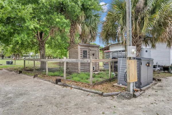 a view of a house with a yard and large trees