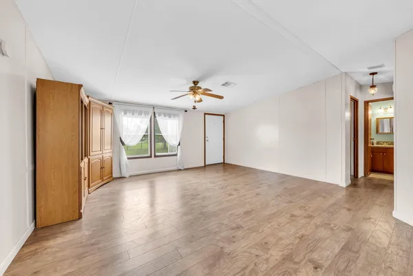 a view of a livingroom with wooden floor and a window