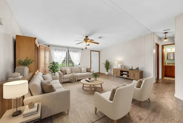 a living room with fireplace furniture and a large window