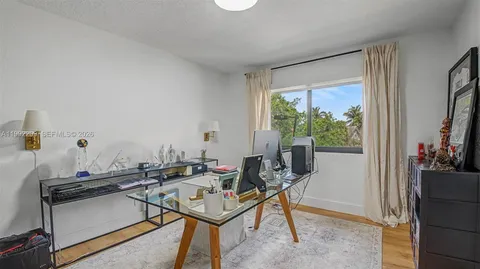 a view of a workspace with furniture and a window