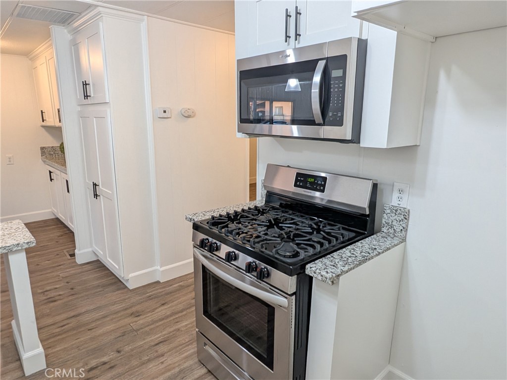 881 North Lake Street, Unit 357 Hemet, CA 92544 - Photo 13 of 29 a kitchen with stainless steel appliances a stove a microwave and cabinets