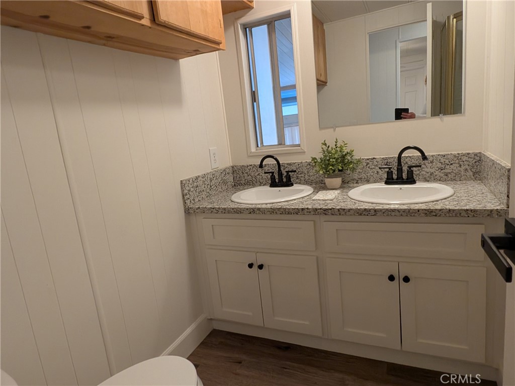 881 North Lake Street, Unit 357 Hemet, CA 92544 - Photo 14 of 29 a bathroom with a granite countertop sink and a mirror