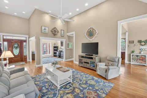 a dining room with wooden floor a chandelier a glass table and chairs