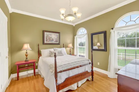 a view of a house with a big yard and large trees