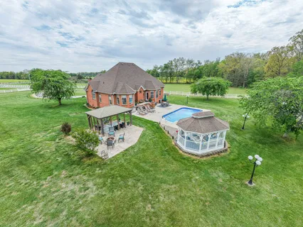 an aerial view of a house with backyard garden and outdoor seating