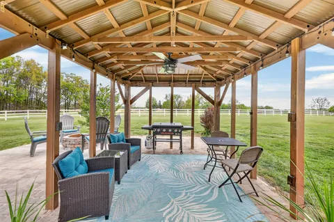 a view of a house with a big yard and large trees