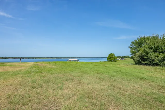 a white house with a big yard and large trees