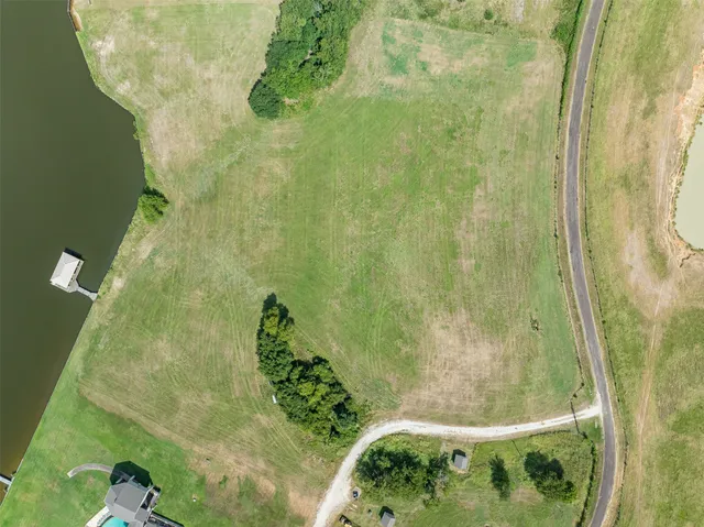 an aerial view of a house with a yard and lake view