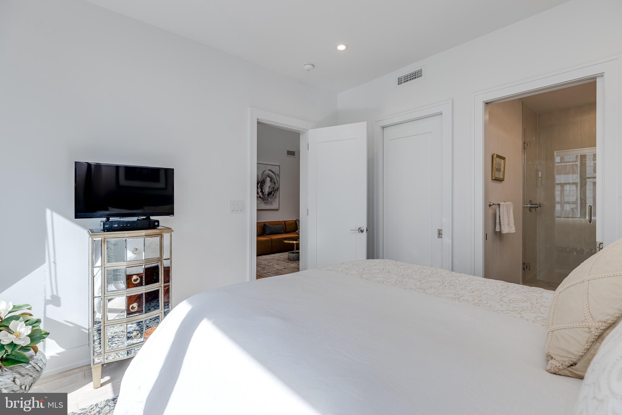 249 South 24th Street, Unit C Philadelphia, PA 19103 - Photo 24 of 35 a large bedroom with a bed and a flat screen tv