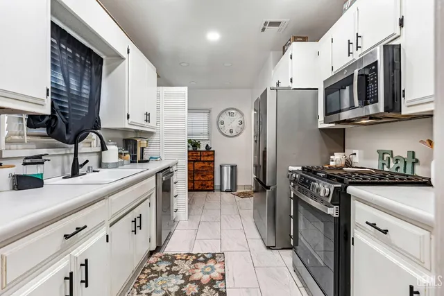 a kitchen with stainless steel appliances granite countertop a refrigerator and a stove