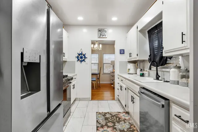 a kitchen with stainless steel appliances granite countertop a refrigerator and a sink