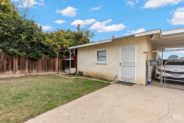 a backyard of a house with barbeque oven and outdoor seating