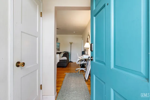 a view of a hallway with a livingroom and a chair