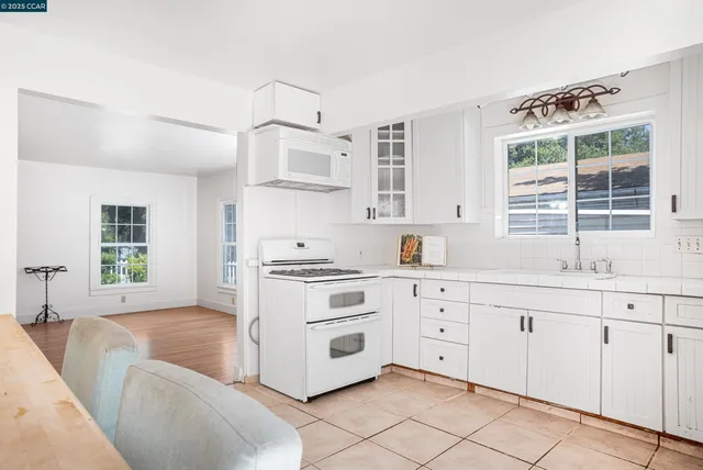 a kitchen with granite countertop white cabinets and white appliances