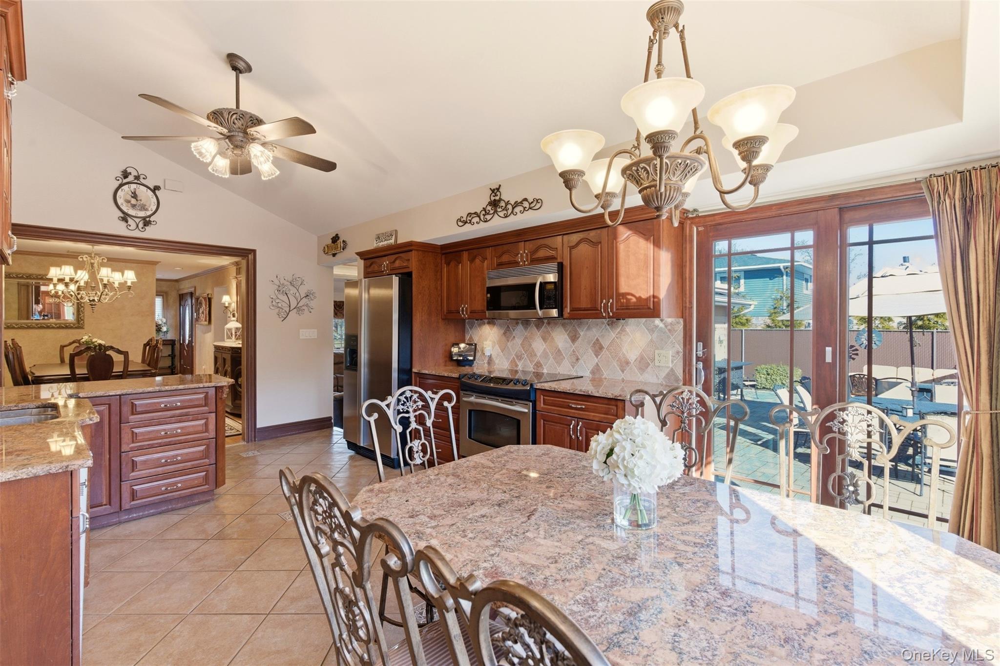 15 Leeward Lane Commack, NY 11725 - Photo 11 of 26 a dining room with wooden floor a chandelier a wooden table and chairs