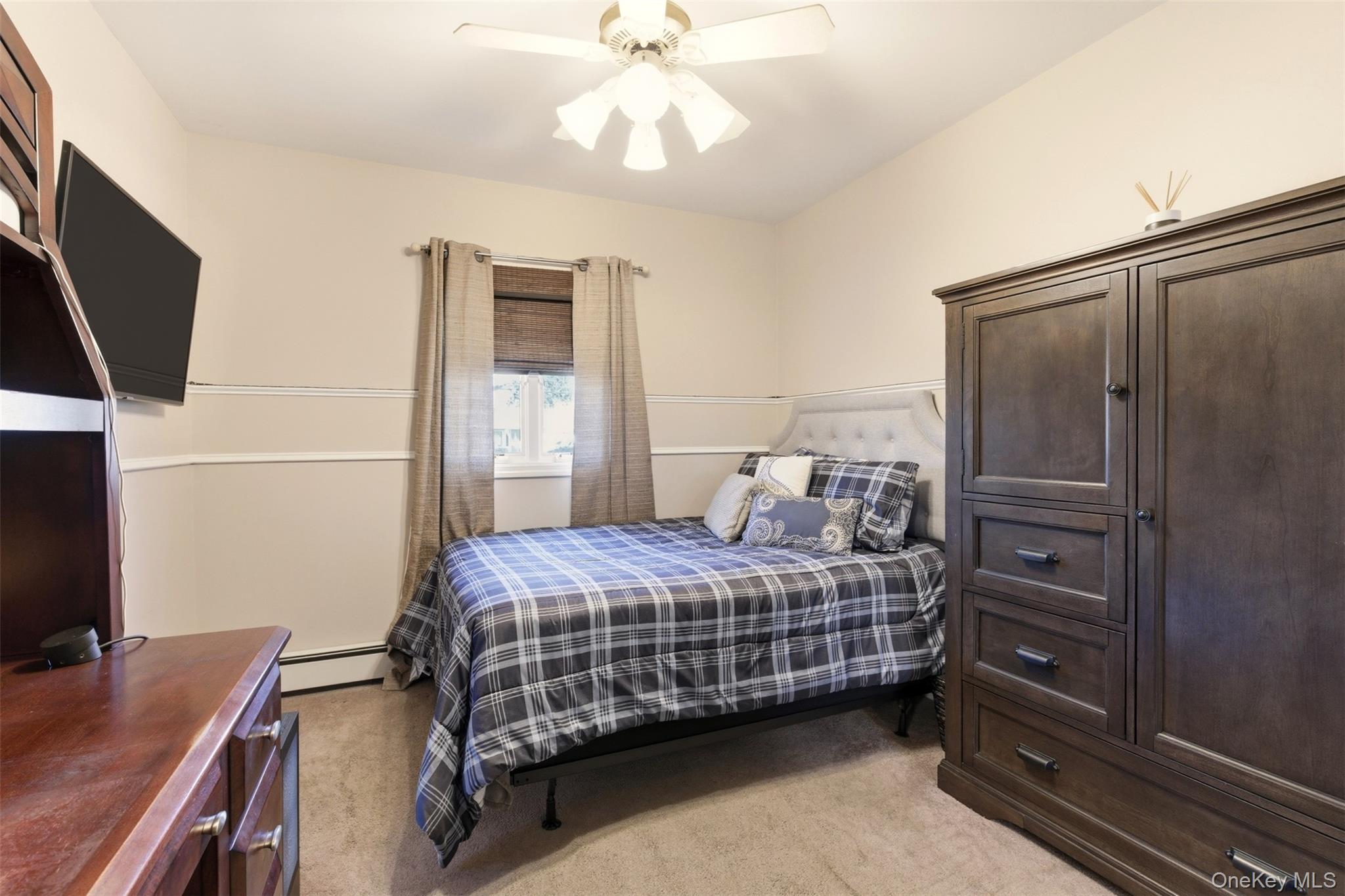 15 Leeward Lane Commack, NY 11725 - Photo 18 of 26 a bedroom with a bed and a flat tv screen on dresser