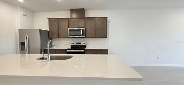 a kitchen with stainless steel appliances a stove a microwave and white cabinets