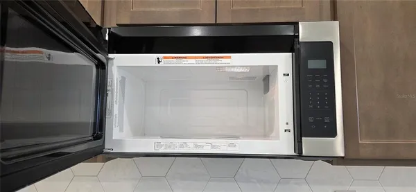 a view of kitchen with microwave and refrigerator