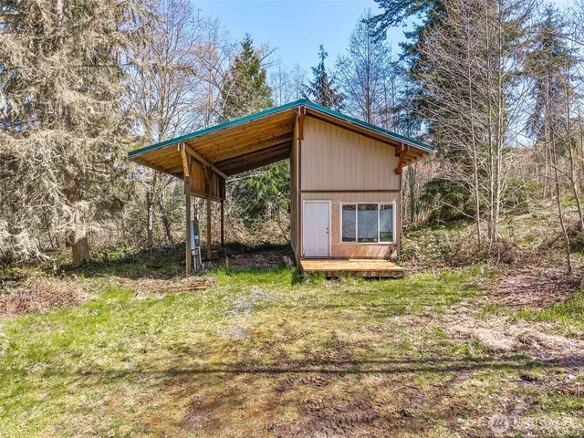 a view of a tiny house with backyard and trees
