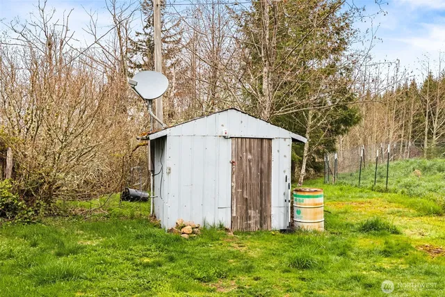 a view of a chair and table in the back yard of the house