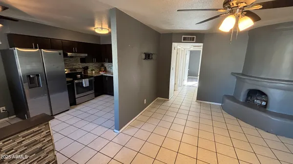 a kitchen with stainless steel appliances kitchen island granite countertop a refrigerator and a stove top oven