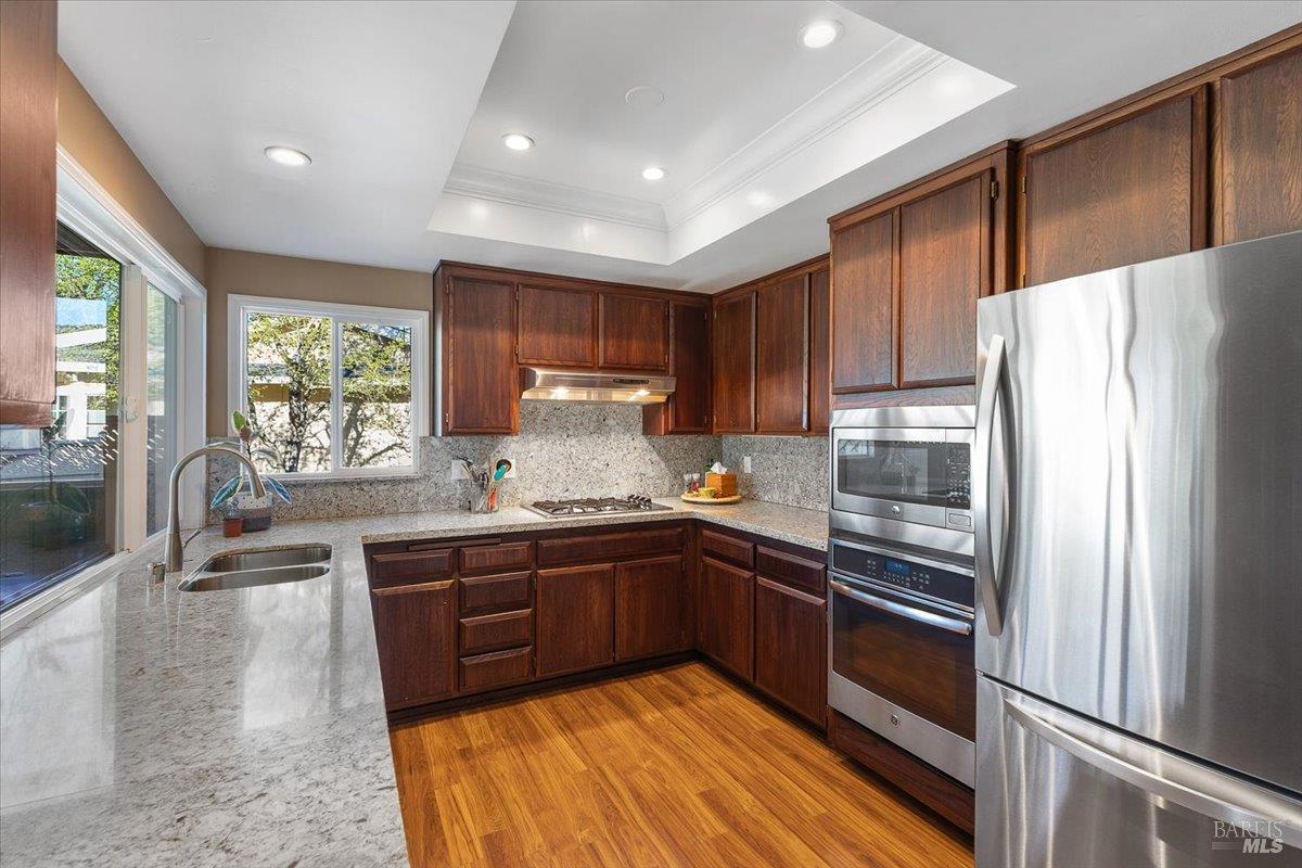 411 Twin Lakes Circle Santa Rosa, CA 95409 - Photo 19 of 41 a kitchen with stainless steel appliances granite countertop a refrigerator a sink dishwasher a stove and white countertops with wooden floor