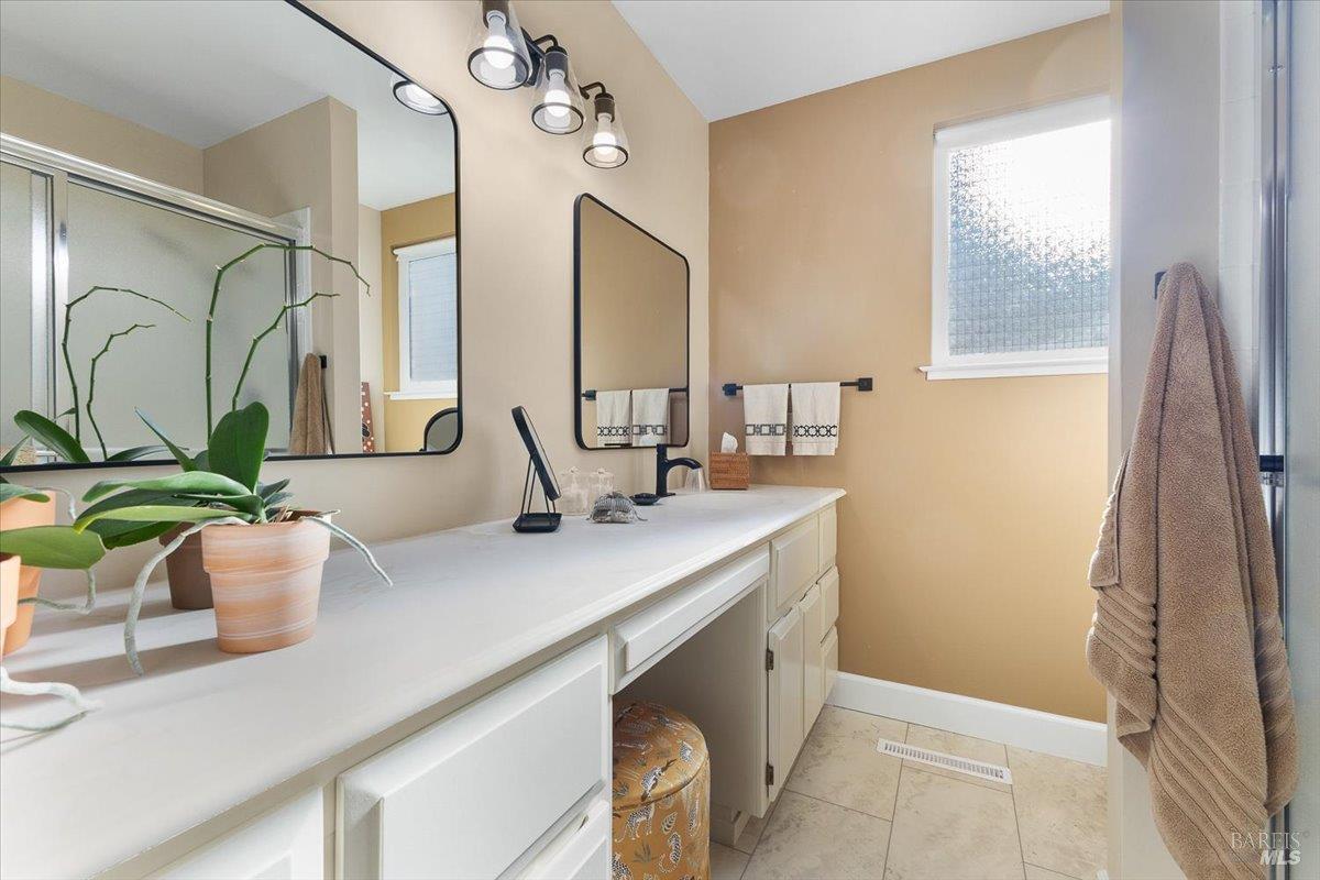 411 Twin Lakes Circle Santa Rosa, CA 95409 - Photo 24 of 41 a bathroom with a double vanity sink a mirror and a shower