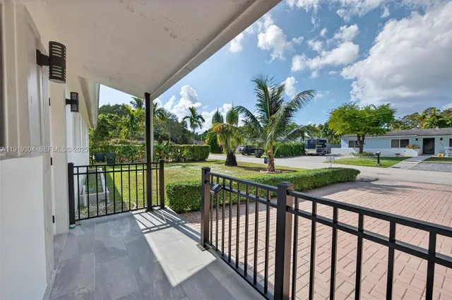 a view of a hallway with wooden floor and a livingroom